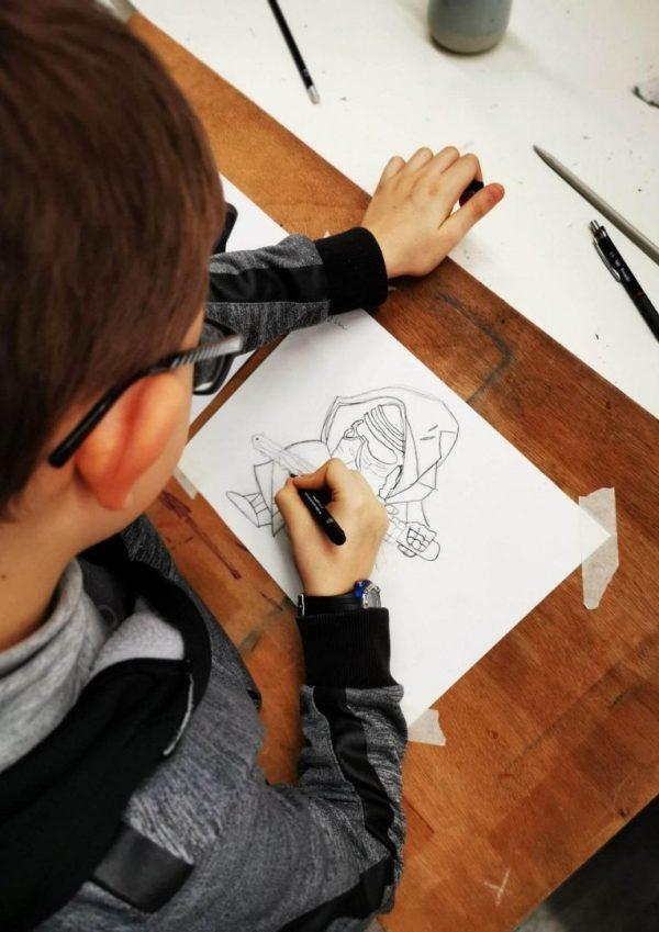 Enfant en train de dessiner pendant un atelier